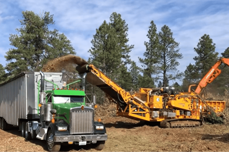 CBI 6800CT Horizontal Grinder Producing Biomass