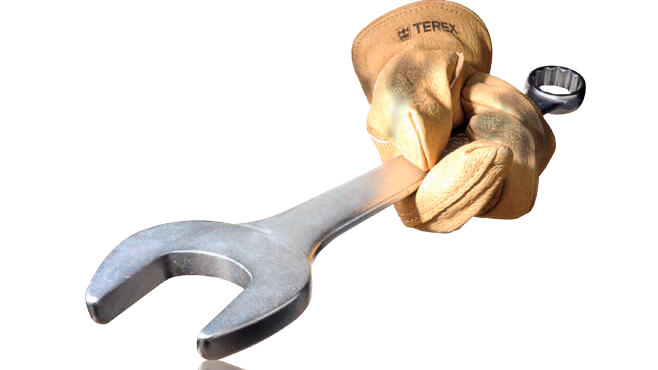 Gloved hand holding wrench